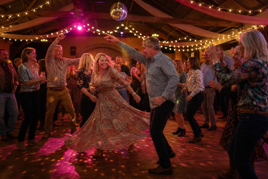 The dance floor in full disco swing under the mirror ball, friends clapping along